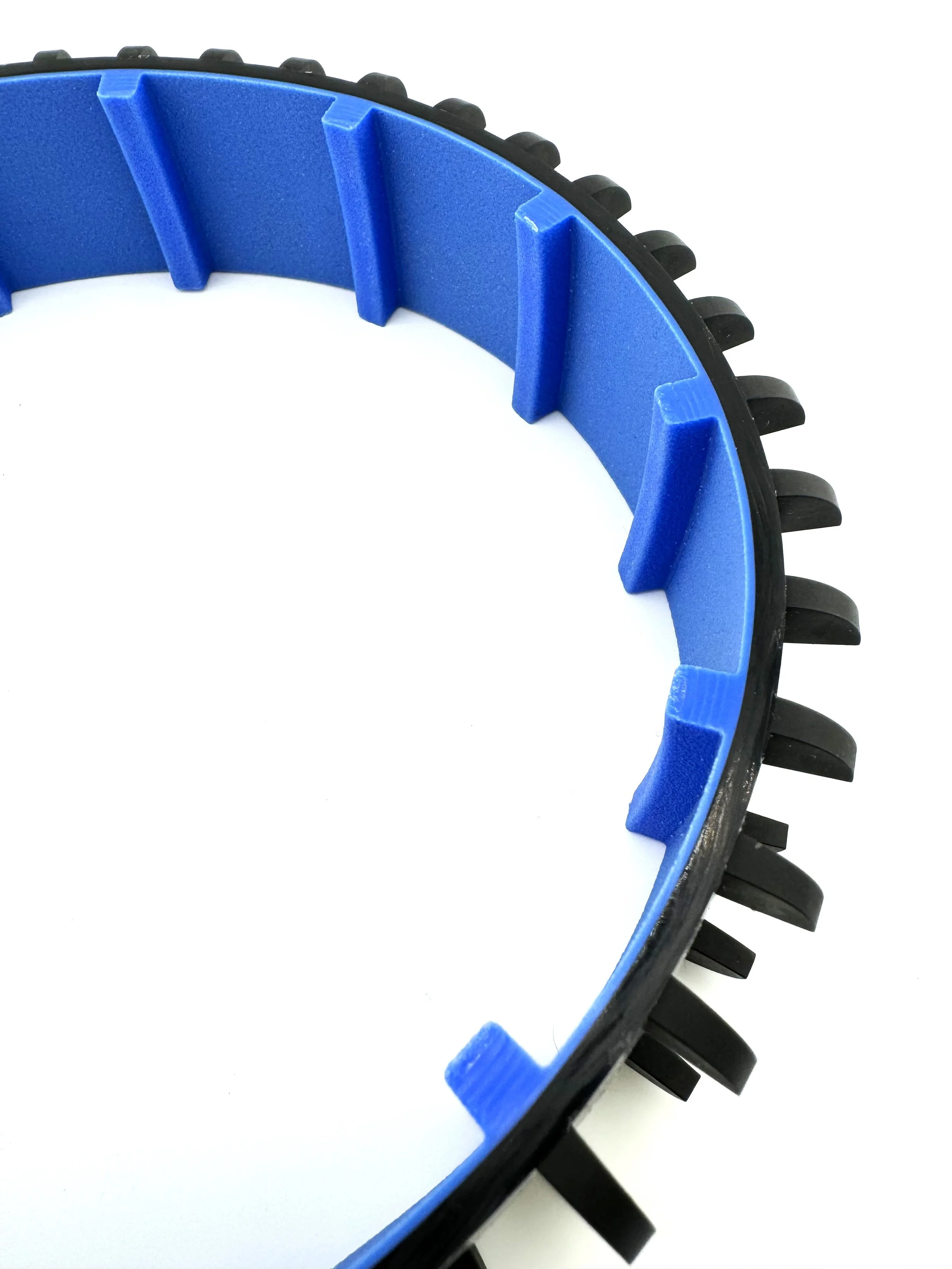 Close-up of a circular rubber track with blue internal guides and black external teeth.