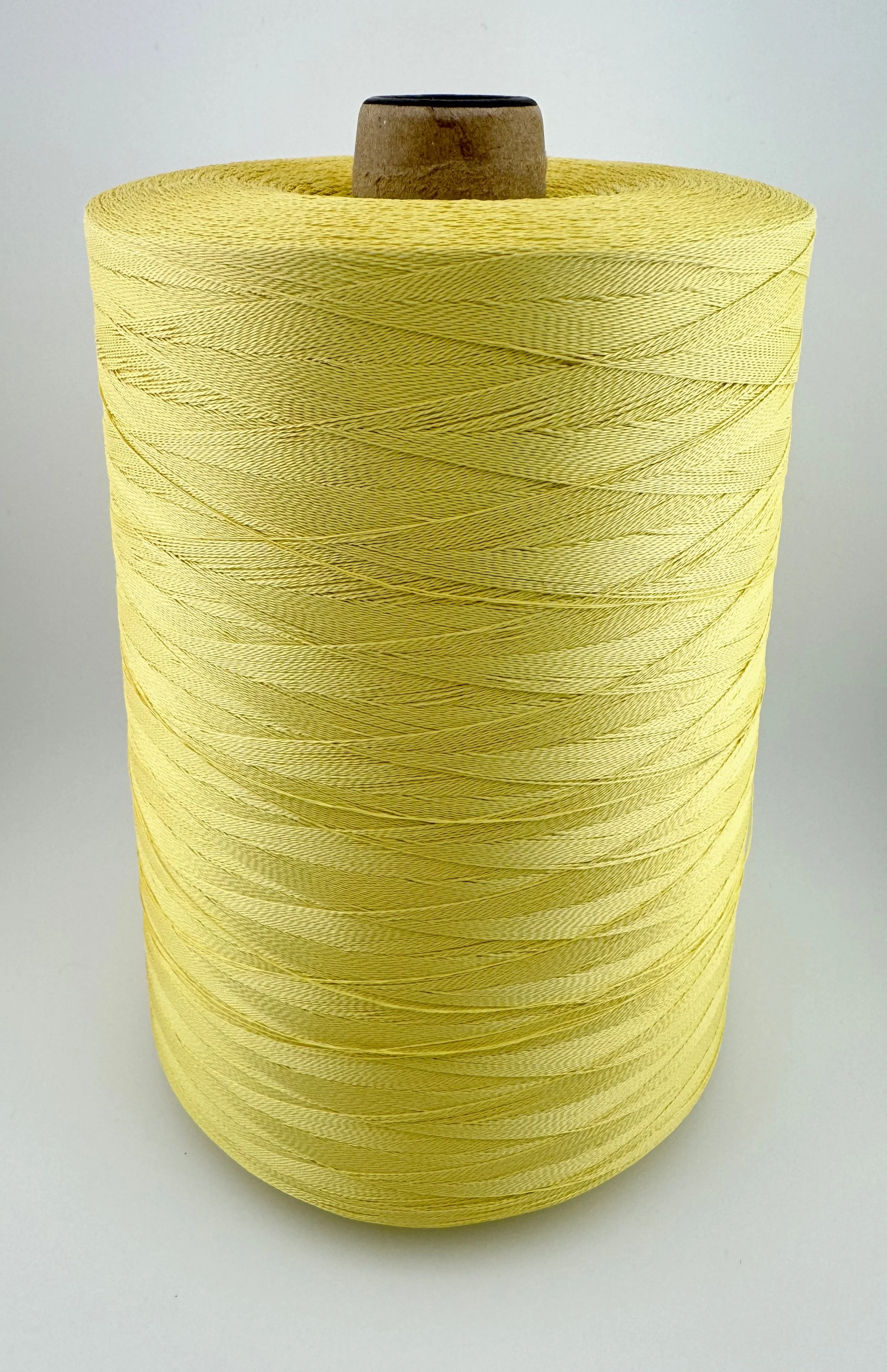 A large spool of yellow thread on a gray background.