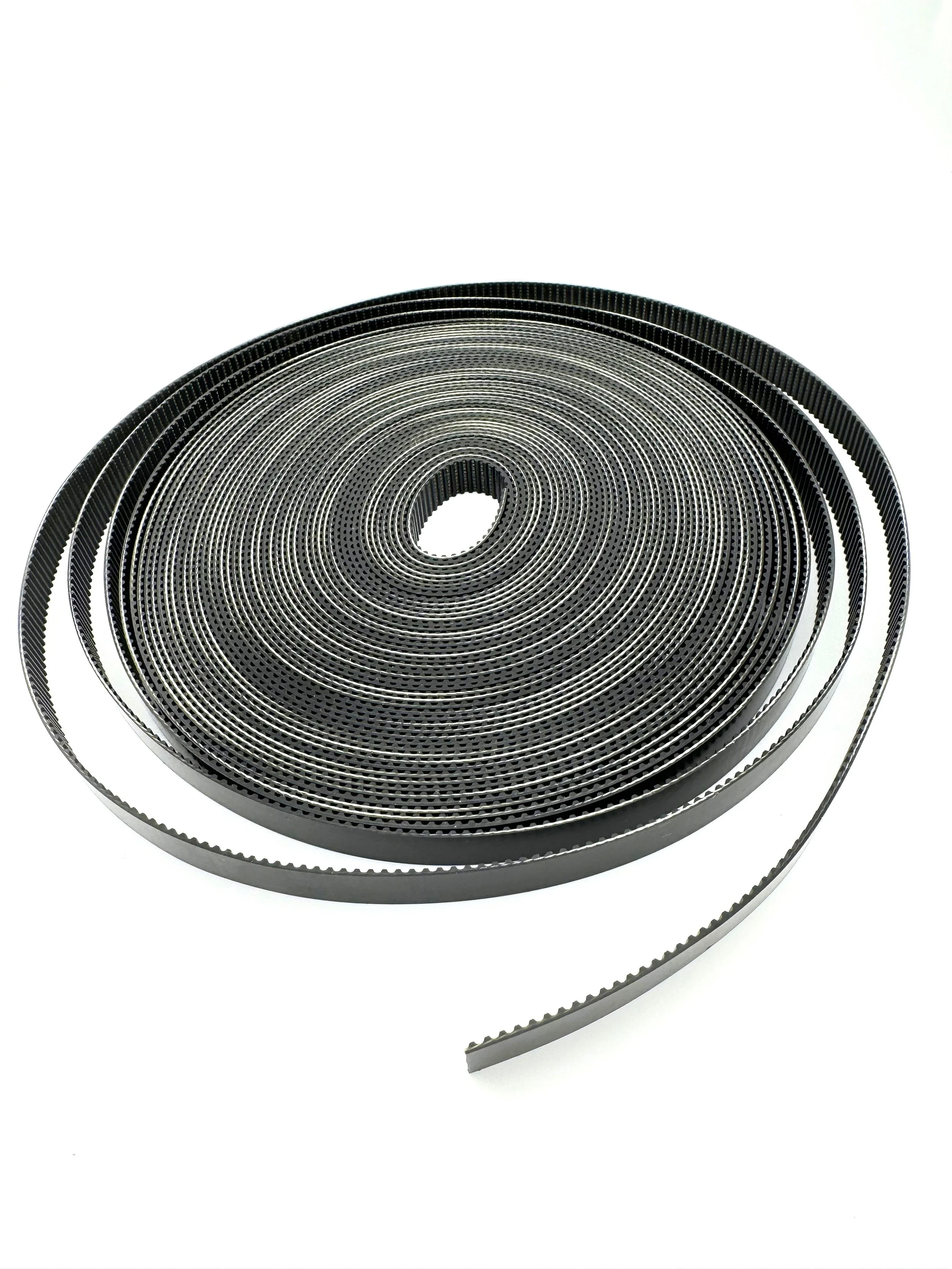 Black endless loop of a perforated timing belt on a white background.
